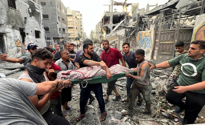 Palestinians carry a casualty after Israeli air strikes in Gaza City