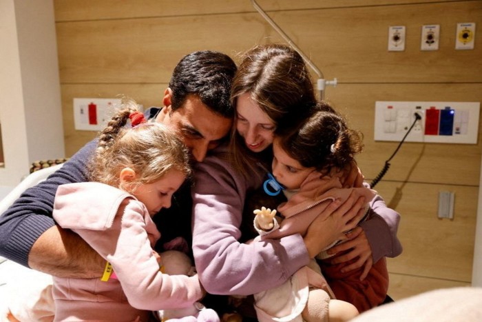 Israeli hostages Aviv and Raz Asher and their mother Doron greet their father Yoni after being released on Friday