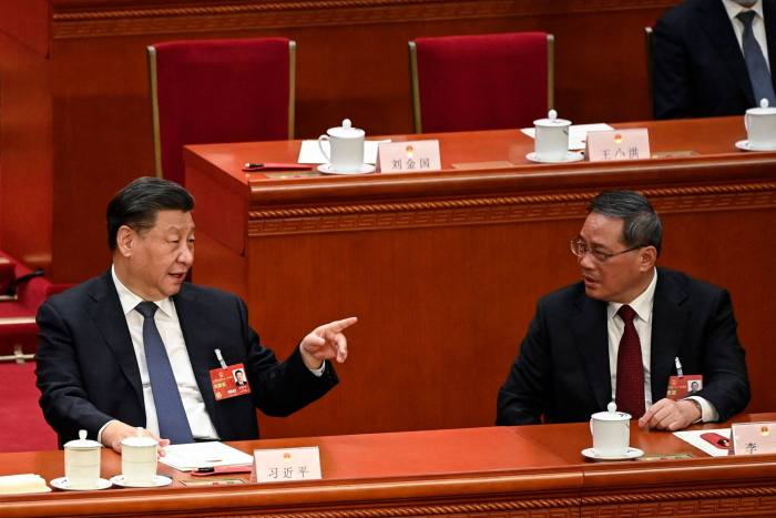 China’s president Xi Jinping, left, speaks with Li Qiang at the National People’s Congress in Beijing in March