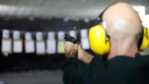 A man fires a gun on a shooting range in a Golan Heights settlement